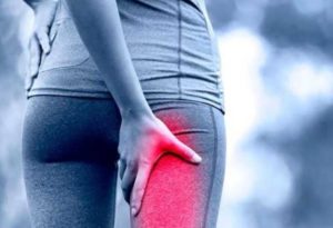 Persona che indica dolore al gluteo e alla gamba causato dalla sindrome del piriforme 